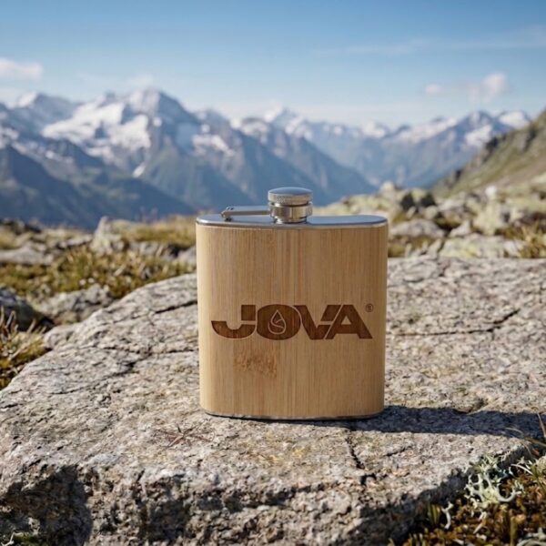 Flasque personnalisée JOVA en bambou et acier inoxydable posée sur un rocher en haute montagne
